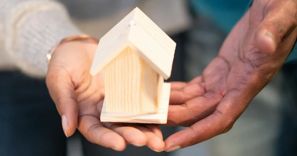 Casinha de madeira simples sendo segurada representando Usucapião