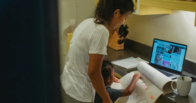 Mulher em pé ajudando seu filho em alguma atividade no computador para ilustrar o assunto guarda unilateral e guarda compartilhada