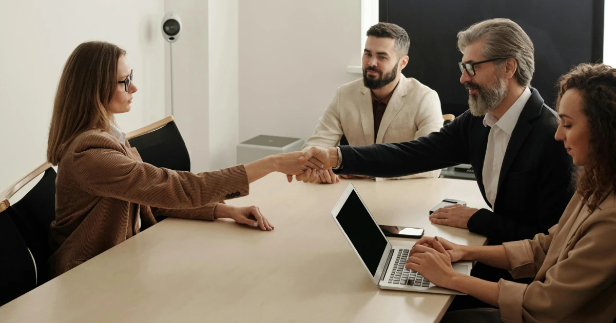 dois homens e duas mulheres fazendo uma reunião e fechando um acordo para ilustrar o tem a doação em vida
